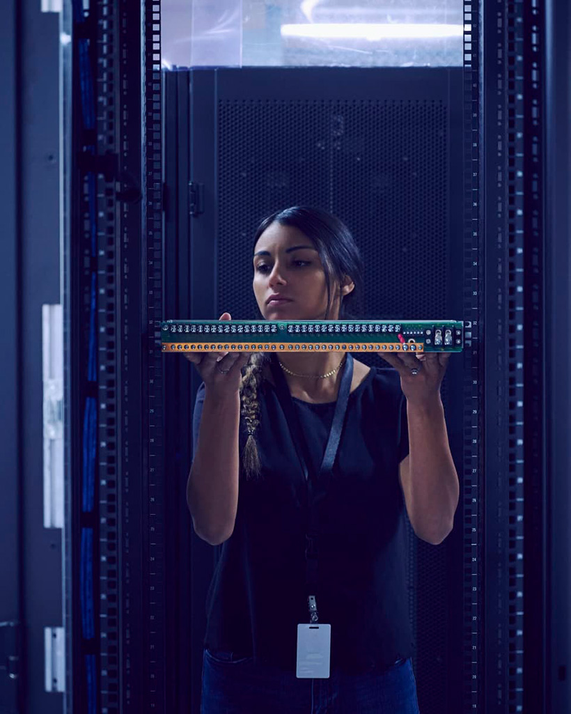 A girl in a data room holding a switch